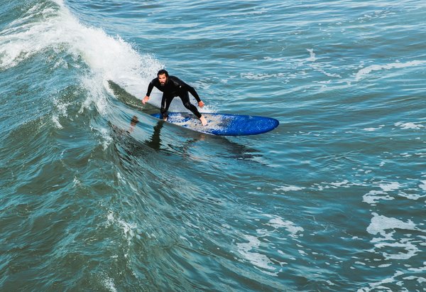 How can professional surfers enhance their paddling speed?